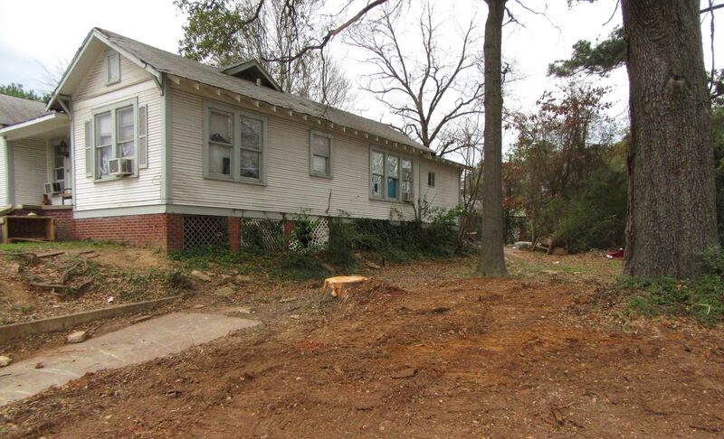 Graded residential lot beside a house after foundation and brick removal